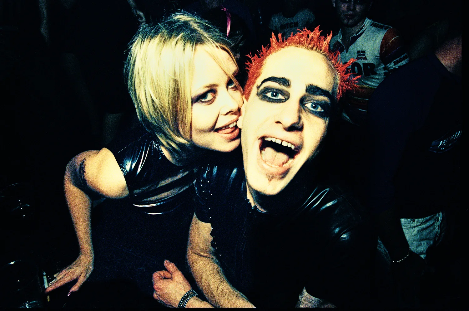 Powderbubble, Red Box, Dublin 1997. Two clubbers in black vinyl pull faces for the camera, one with spiked red hair and dark eye makeup. 35mm photograph by Brendan Duffy.