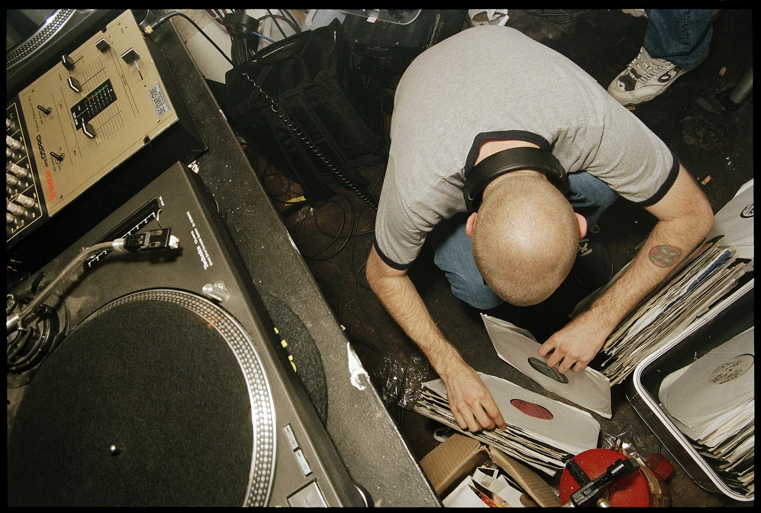 Richie Hawtin, Columbia Mills, Dublin 1998. Seen from above beside the decks, Richie Hawtin goes through crates of records. 35mm photograph by Brendan Duffy.